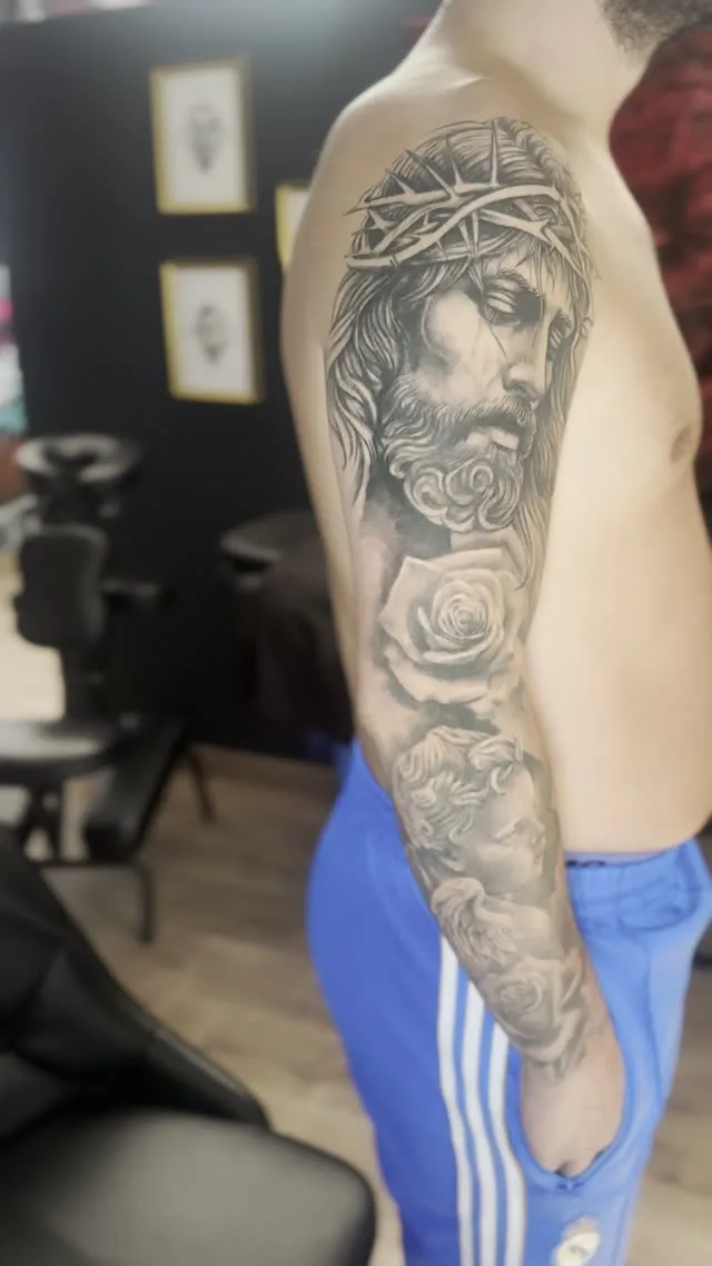 Manga religiosa con Cristo y rosa — tatuaje terminado — Clandestine Art Studio Marmolejo